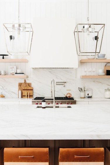 кухня шеф-повара из белого мрамора с кухонным краном на гусиной шее, встроенной кухонной раковиной и наполнителем для кастрюль у плиты - удобно для приготовления пищи