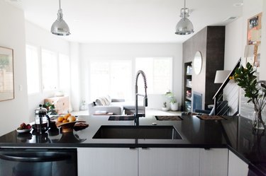 встроенная кухонная раковина и кухонный смеситель с черными столешницами